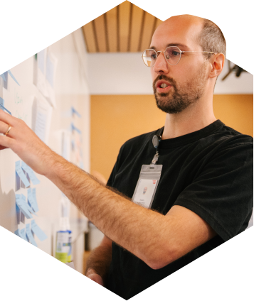 teacher with a black shirt and glasses at a dry-erase board